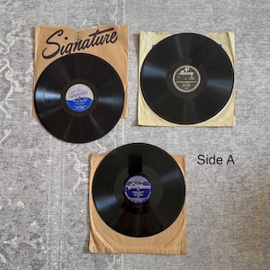 May include: Three vintage vinyl records with black discs and paper sleeves. Two records have "Signature" printed on the sleeves, and one has "Mercury". The text "Side A" is visible on the bottom right.