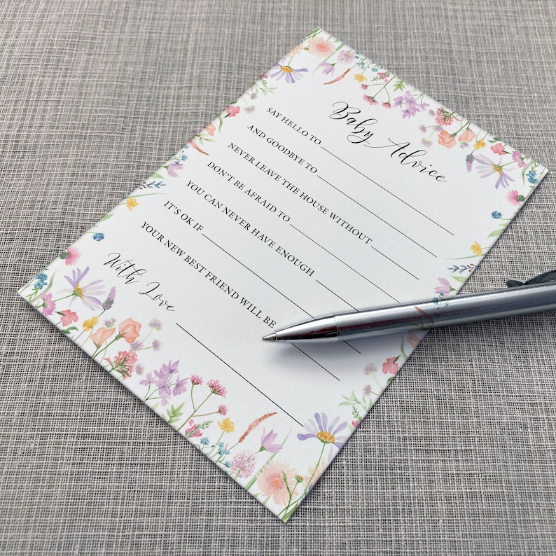 Baby Advice Baby shower game card featuring a pink, yellow, Lilac and peach wildflower design on a white background. Shown alongside a pen