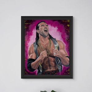 May include: Framed artwork featuring a muscular man with long hair, wearing a vest and gold necklaces, set against a pink and gold background. The artwork is in a black frame, displayed on a white wall. A vase with green leaves is in the foreground.