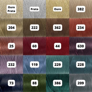 Peut inclure: Une collection de 16 bobines de fil de différentes couleurs, dont l'or, l'argent, le brun, le rouge, le violet, le gris, le bleu, le vert et le noir. Chaque bobine est étiquetée avec un numéro.