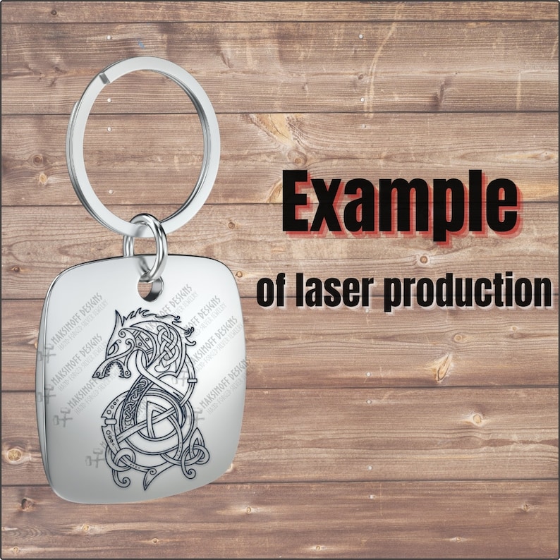 Pu&ograve; includere: Un portachiavi in ​​argento con un'etichetta quadrata che presenta un design inciso a laser in bianco e nero di una testa di lupo con un motivo a nodo. Il testo "MAKSIMOFF DESIGNS" &egrave; ripetuto attorno al bordo dell'etichetta. Il portachiavi &egrave; un esempio di produzione laser.