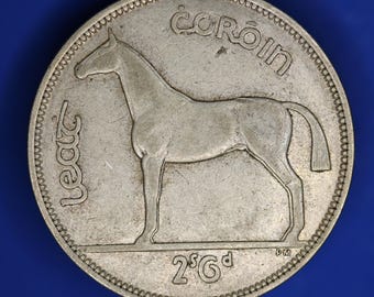 May include: A silver coin featuring a detailed depiction of a horse. The coin has the inscription "COROIN" at the top and "LEAT" on the left side. The value "2'6" is displayed at the bottom. The coin is set against a blue background.