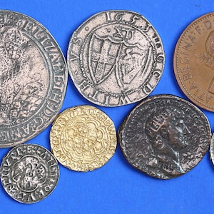 May include: A collection of eight antique silver and gold coins, including a gold coin with a floral design, a silver coin with a portrait of a woman, and a silver coin with a shield design.