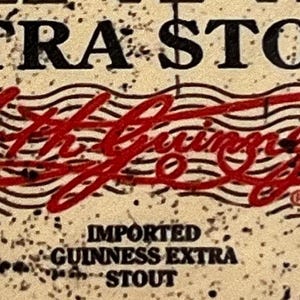 May include: A close-up of a vintage-style label for Guinness Extra Stout beer. The label features a red stamp with the text "Arthur Guinness Son & Co.", along with the words "Imported Guinness Extra Stout".