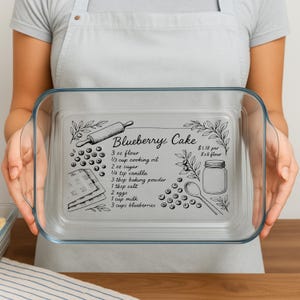 May include: A clear glass baking dish with a recipe for blueberry cake printed on the bottom. The recipe includes ingredients like flour, sugar, and blueberries. The dish is rectangular with rounded corners and handles.