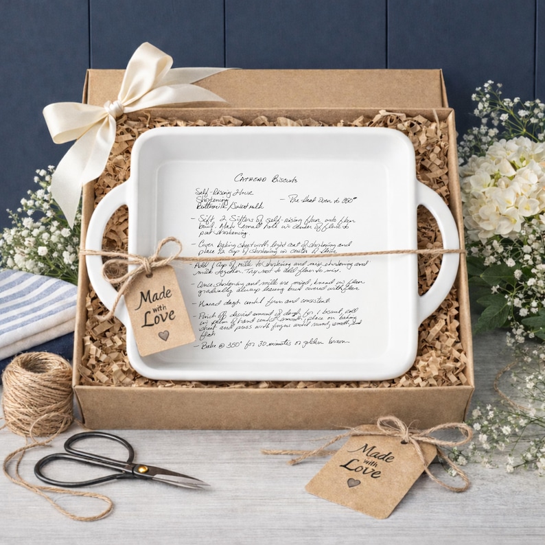Custom recipe baking dish gift, white ceramic casserole dish styled in a rustic gift box with twine wrap and handwritten recipe engraving visible. Thoughtful personalized kitchen gift idea for weddings, housewarmings, anniversaries, or memorial recipe keepsakes.