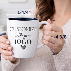 Personalized logo coffee mug with size details, 18 oz glossy white ceramic bistro cup with black interior, precision laser engraved for long-lasting customization. Measures 5 1/4 inches wide and 4 3/8 inches tall, offering a generous capacity for daily use. Ideal for company swag, promotional giveaways, trade shows, holiday corporate gifts, and branded office drinkware.