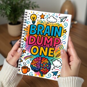 May include: A spiral-bound notebook held by hands, featuring the text "BRAIN DUMP ONE" in vibrant colors. The cover design includes a brain illustration, a lightbulb, stars, clouds, and a rainbow, suggesting a creative or organizational theme.