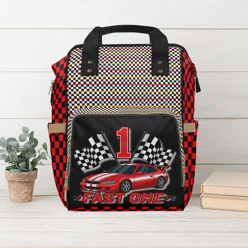 Racing toddler travel backpack with car and checkered flag design. Perfect for preschool, daycare, or road trips. Durable and roomy toddler bag for travel.