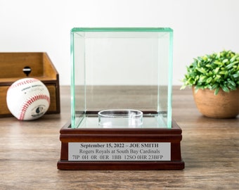 May include: A wooden display case with a glass top and a plaque that reads "September 15, 2022 - JOE SMITH Rogers Royals at South Bay Cardinals 7IP OH OR OER IBB 12SO 0HR 23BFP"