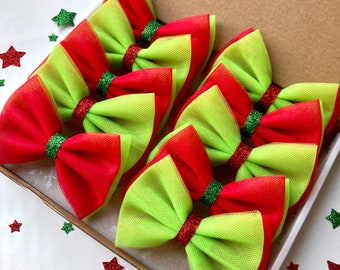 May include: A set of six green and red tulle bows with glitter trim. The bows are arranged in a box.