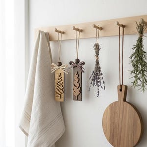 Minimal farmhouse kitchen décor with rustic wooden ornaments hanging on wood pegs.