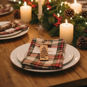 Farmhouse Christmas place setting with rustic wood ornament gift tag on plaid napkin.