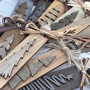 Rustic handmade wooden Christmas ornaments in neutral tones close-up detail shot.