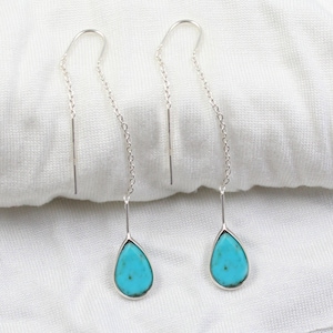 Könnte beinhalten: Ein Paar silberne Ohrringe mit türkisfarbenen Tropfen.