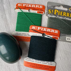May include: Three spools of green, dark green, and grey embroidery thread with labels that read "St. Pierre" and "Repriser Broder Festonner". The labels also include the colour numbers 868, 890, and 814.