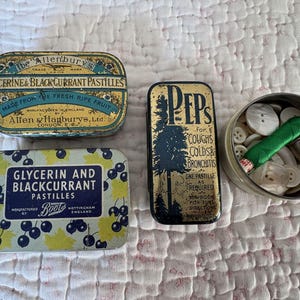 A Vintage Tin filled with 100 Vintage French Mother of Pearl Buttons A Thimble and A Spool of Silk Thread