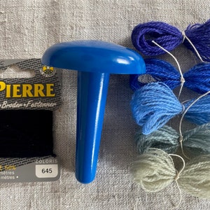 May include: A blue plastic darning mushroom with a small spool of black thread and four skeins of blue yarn in various shades. The packaging includes the text "MARINE TOUS TEXTILES ST PIERRE Repriser Broder Festonner LAINE 50% POLYAMIDE 50% Carte de 40 mètres 4 Fils de 10 mètres COLORIS 645".