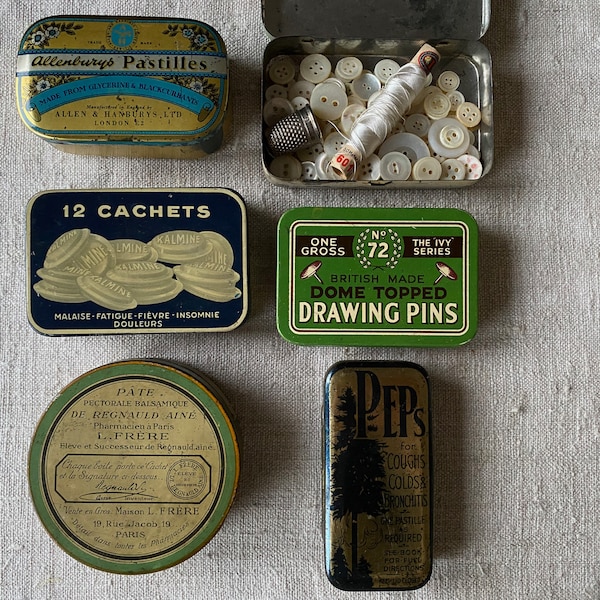 A Vintage Tin filled with 100 Vintage French Mother of Pearl Buttons A Thimble and A Spool of Thread