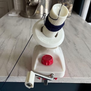 A Vintage Japanese Red and White Plastic and Metal Hand Operated Ball Winder for Wool Thread String