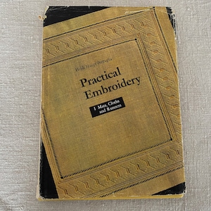 May include: A book titled "Practical Embroidery: 1. Mats, Cloths and Runners" by Heidi Haupt-Battaglia. The cover features a gold background with a decorative border.
