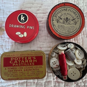 A Vintage Tin filled with 100 Vintage French Mother of Pearl Buttons A Thimble and A Spool of Red Silk Thread