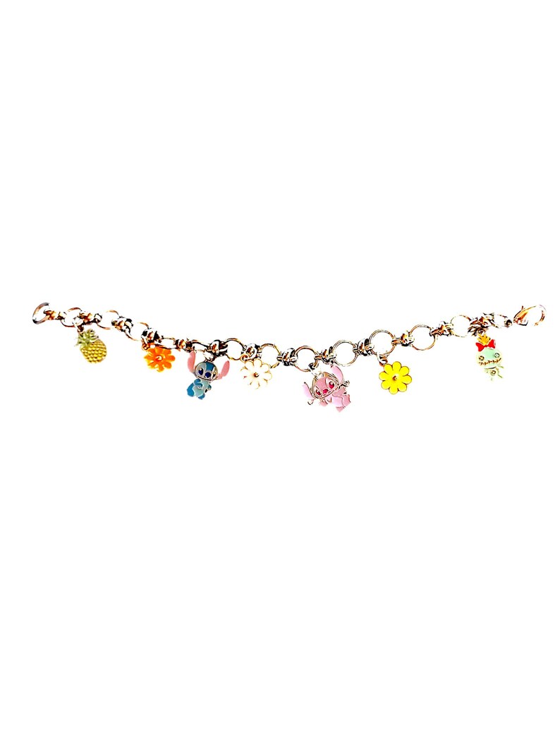 May include: A gold-colored charm bracelet featuring colorful enamel charms. Charms include a pineapple, flowers, and cartoon characters. The bracelet is on a white background.