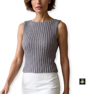 May include: A sleeveless, gray crochet top with a ribbed texture. The top has a boat neck and a fitted silhouette. The image shows the top on a person, paired with a white skirt. The top is a neutral color, suitable for various outfits.