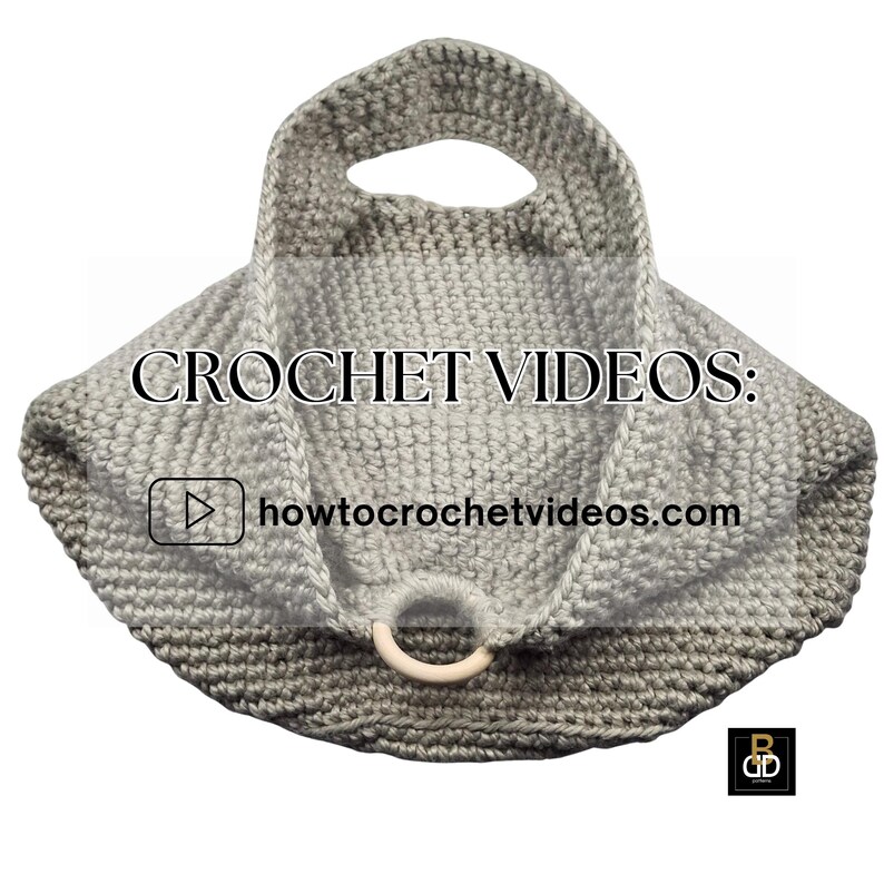 May include: A handmade crochet bag in shades of gray, featuring a circular handle and a wooden ring closure. The bag has the text "CROCHET VIDEOS:" and "howtocrochetvideos.com" on it.