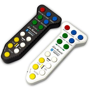 May include: Two golf simulator remotes, one black and one white, with multiple colored buttons. The remotes have text that reads "Sim Remote" and "WORKS WITH GSPRO". The buttons are labeled with functions like "Putter" and "Target".