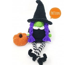May include: Crocheted witch gnome with purple hair, black hat, and black and white striped legs. The gnome is sitting next to a crocheted orange pumpkin. The text "PATTERN!" is in a speech bubble.