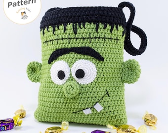 May include: A green crochet pouch shaped like a monster with black hair, thick black eyebrows, white eyes with black pupils, a small nose, and two white teeth. The pouch features a black top border and a black handle. Text reads PDF Pattern.