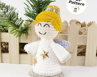 Könnte beinhalten: Eine gehäkelte Engelsfigur mit weißem Kleid, gelbem Haar und silbernem Besatz. Der Engel hat ein lächelndes Gesicht, goldene Sternverzierungen auf dem Kleid und einen kleinen goldenen Stern auf dem Kopf. Ein Abzeichen zeigt PDF Pattern Knitting Kitty.