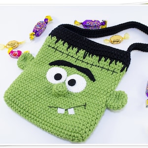 Puede incluir: Bolsa de truco o trato de Halloween de crochet verde con forma de monstruo de Frankenstein con ojos negros, dientes blancos y una cicatriz negra cosida. La bolsa tiene una correa de crochet negra.