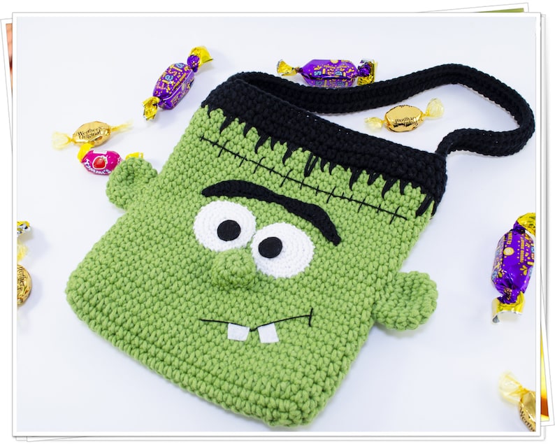Puede incluir: Bolsa de truco o trato de Halloween de crochet verde con forma de monstruo de Frankenstein con ojos negros, dientes blancos y una cicatriz negra cosida. La bolsa tiene una correa de crochet negra.
