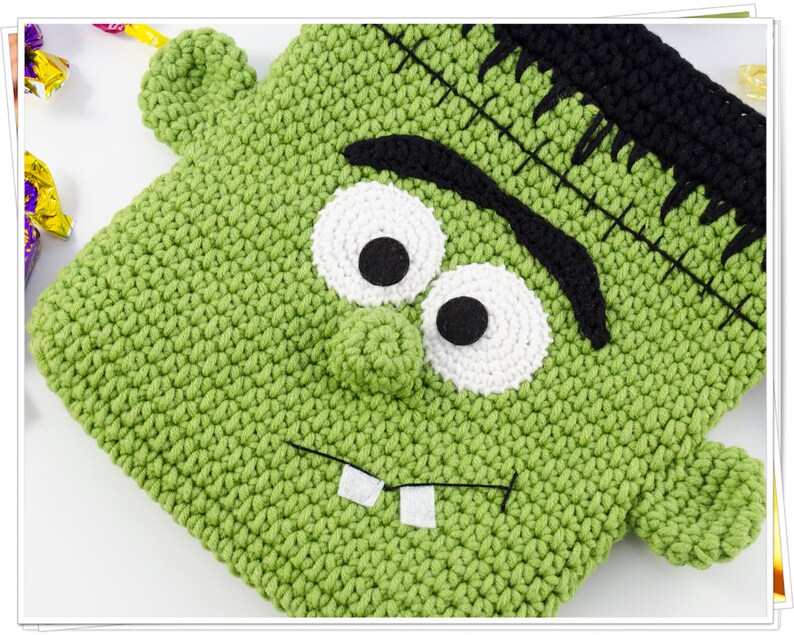 Puede incluir: Bolsa de truco o trato de Halloween de Frankenstein de crochet verde con ojos negros, escler&oacute;tica blanca y boca cosida.