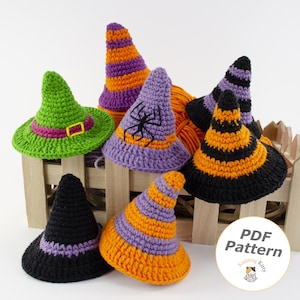 Könnte beinhalten: Eine Sammlung von sechs gehäkelten Hexenhüten in verschiedenen Farben wie Grün, Lila, Orange und Schwarz, einige mit Streifen oder einer schwarzen Spinnenapplikation. Ein rundes weißes Etikett enthält den Text PDF Pattern.