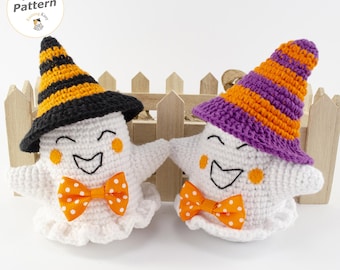 Op de afbeelding: Twee gehaakte witte spookfiguren met oranje gestippelde vlinderdassen en geborduurde gezichten. De een draagt een zwart-oranje gestreepte hoed, de ander een paars-oranje gestreepte hoed. Een ronde badge toont de tekst PDF Pattern.