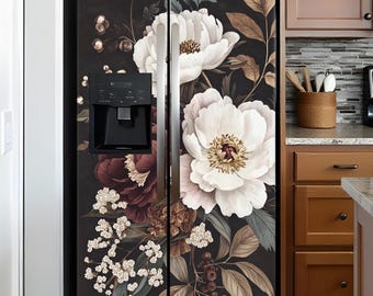 Può includere: Un frigorifero nero con un design floreale con fiori bianchi, rosa e bordeaux sulle porte. Il frigorifero si trova in una cucina con armadietti marroni e un backsplash piastrellato.