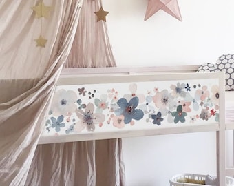 May include: A white wooden loft bed featuring a floral decal on the side panel with blue, pink, and grey flowers. The bed includes a beige fabric canopy with gold star accents, a white mattress, and a grey and white polka dot cloud pillow.