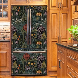 May include: A stainless steel refrigerator with a black floral patterned design. The refrigerator is in a kitchen with wood cabinets.