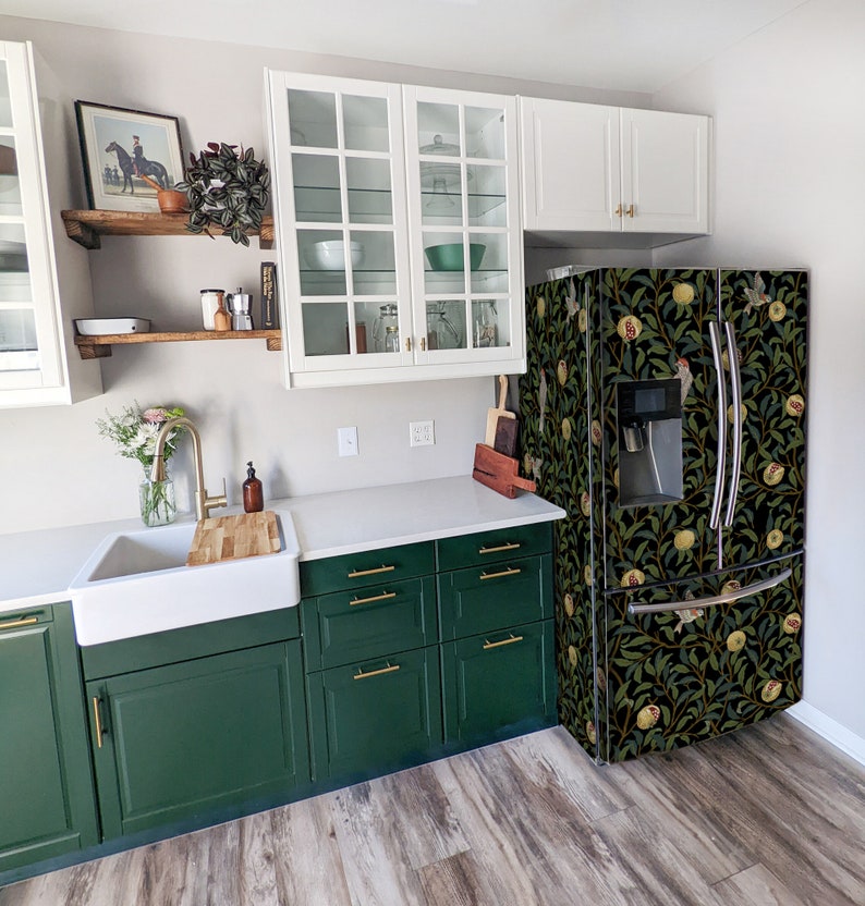 May include: A green kitchen with white cabinets, a stainless steel refrigerator with a floral design, and a white countertop. The refrigerator has a water dispenser and an ice maker.