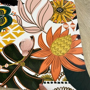 A white fridge wrap with a colorful floral pattern. The pattern includes pink, orange, yellow, green, and black flowers and leaves.