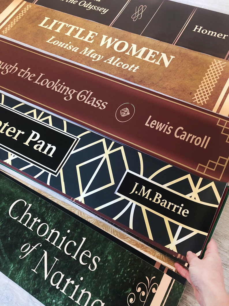 K&ouml;nnte beinhalten: Ein Stapel von f&uuml;nf B&uuml;chern mit dekorativen R&uuml;ckseiten. Das oberste Buch tr&auml;gt den Titel "Little Women" von Louisa May Alcott. Das zweite Buch tr&auml;gt den Titel "Through the Looking Glass" von Lewis Carroll. Das dritte Buch tr&auml;gt den Titel "Peter Pan" von J.M. Barrie. Das vierte Buch tr&auml;gt den Titel "Chronicles of Narnia".