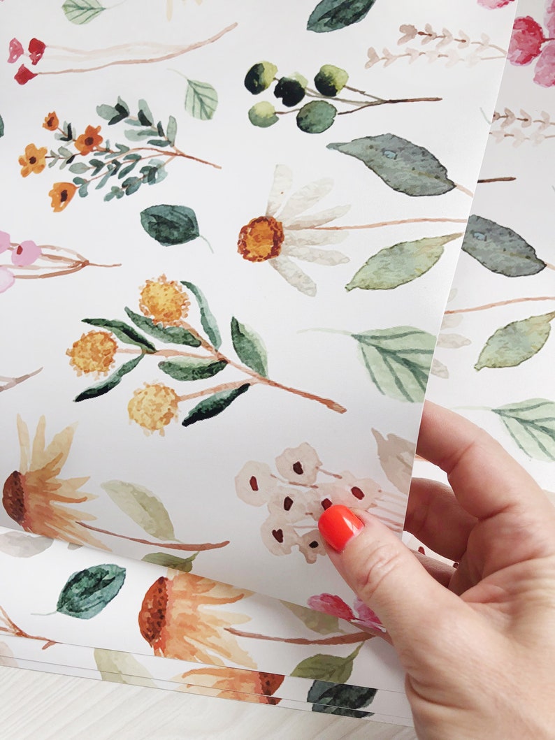 May include: White wrapping paper with a repeating pattern of watercolor flowers and leaves in shades of green, yellow, orange, pink, and brown.
