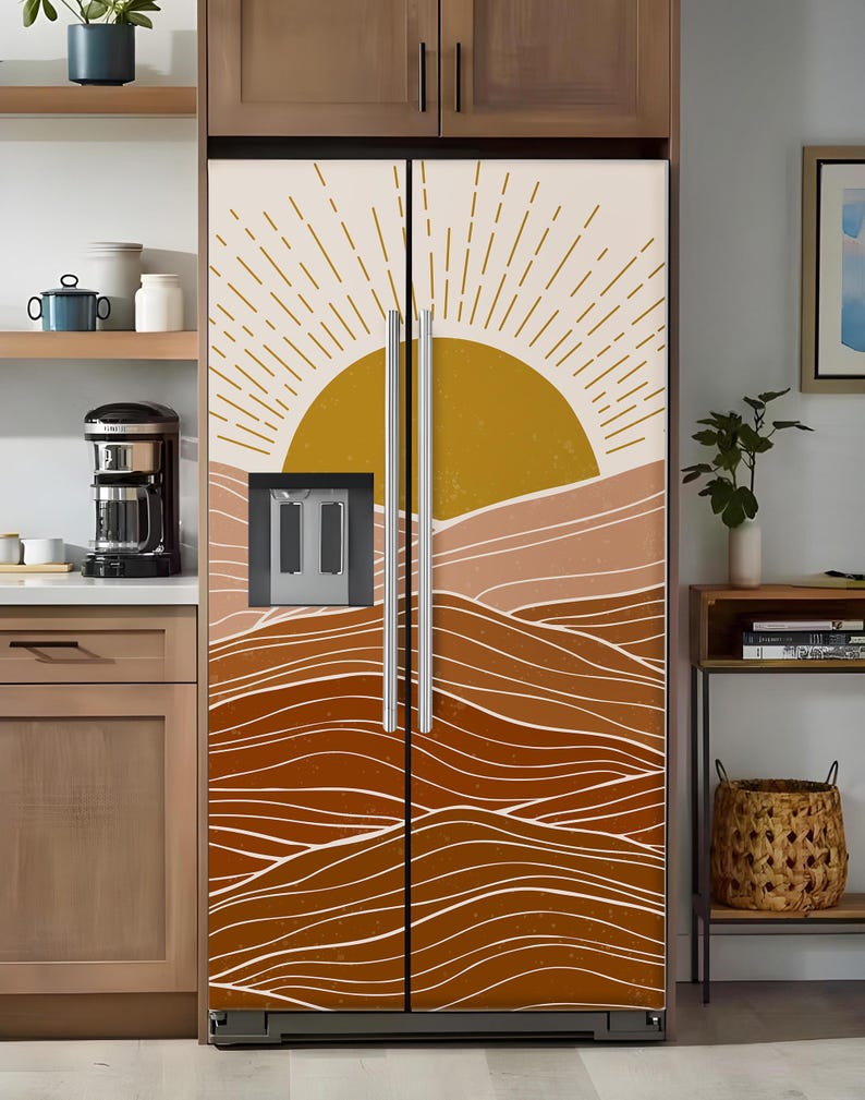 K&ouml;nnte beinhalten: Eine K&uuml;hlschrankfolie mit einem W&uuml;stenlandschaftsdesign. Das Kunstwerk zeigt eine goldene Sonne, geschichtete braune H&uuml;gel und wei&szlig;e wellenf&ouml;rmige Linien. Die Folie bedeckt die gesamte K&uuml;hlschrankt&uuml;r.