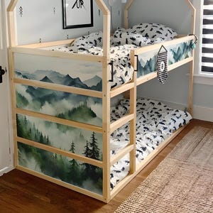 Pode incluir: Uma cama de beliche de madeira com acabamento natural. A cama apresenta uma cena de montanha nos painéis laterais e é vestida com roupa de cama com um padrão em preto e branco. A estrutura da cama tem um topo em forma de casa.