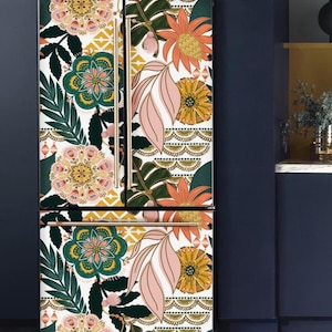May include: A refrigerator with a vibrant floral design. The pattern features large flowers in shades of pink, orange, yellow, and green, set against a white background. The refrigerator has gold-colored handles and is a French door style.