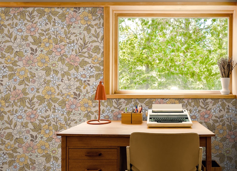 May include: A vintage-style desk with a floral wallpaper background. The desk has a wooden top, drawers, and a chair. There is a typewriter, a lamp, and a pencil holder on the desk.