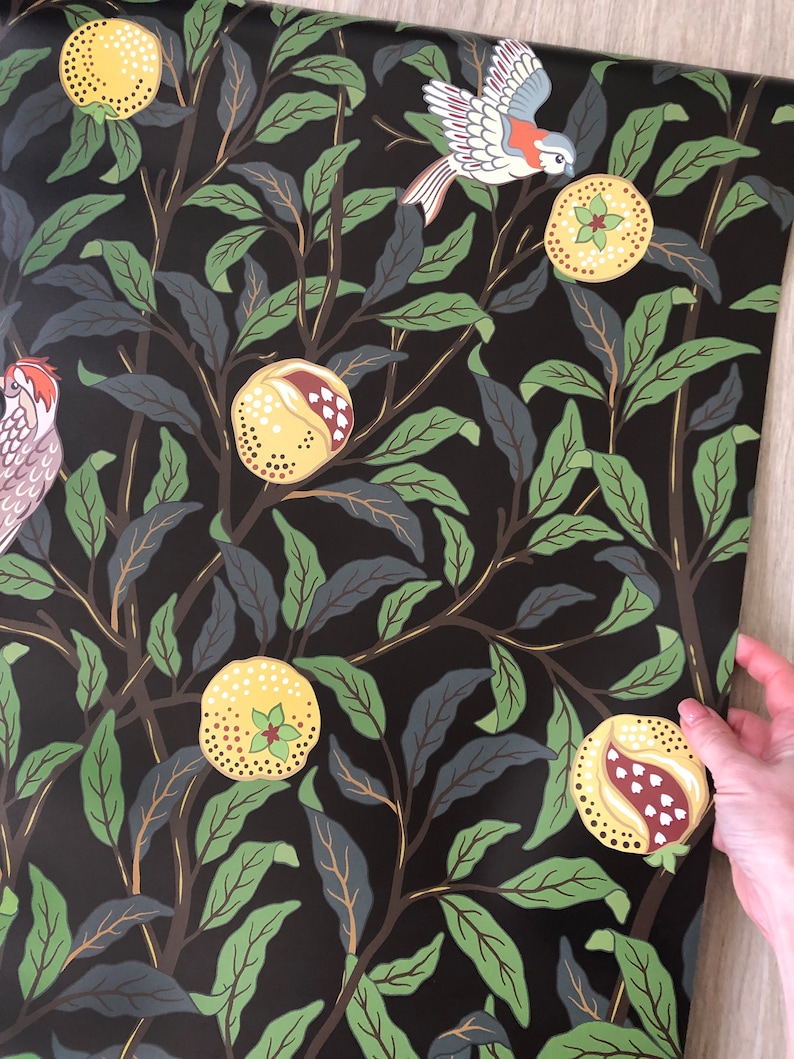 May include: Black wallpaper with a repeating pattern of green leaves, yellow pomegranates, and red and white birds.